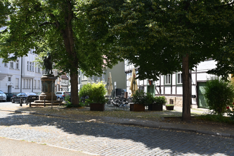 Denkmal und Gastronomie unter Bäumen - eine grüne Insel mitten in der Altstadt